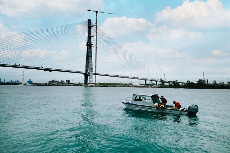 Researchers with the Great Lakes Institute for Environmental Research collect a water sample from a boat in the Detroit River