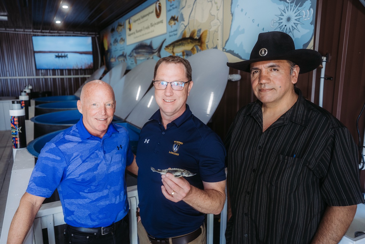 Anishinaabeg Kinomaagewgamig principal Craig Lindsay, left, Dr. Trevor Pitcher, director of the University of Windsor's Freshwater Restoration Ecology Centre, and teacher Mino Giizhgad gather at the Giigoonyig Enjintaawgiwaad hatchery during Friday's opening ceremony on Walpole Island First Nation.
