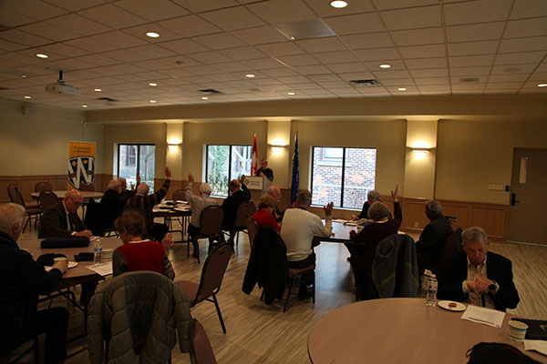 View of the room, people voting on motion.