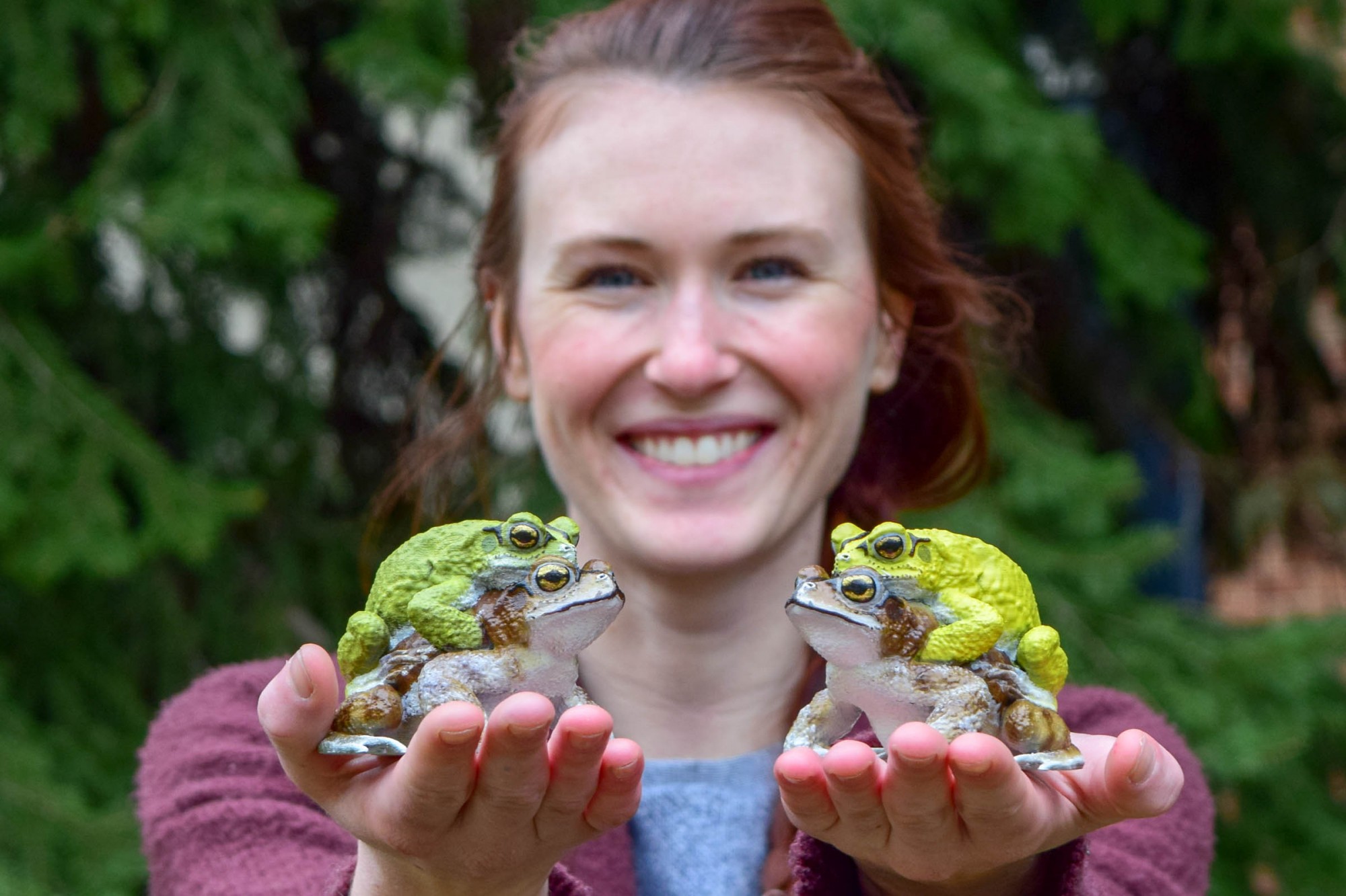Student holding frogs