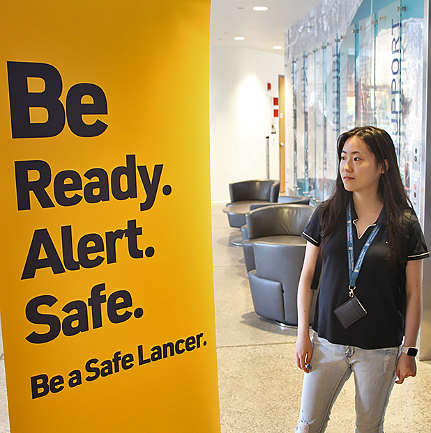 student looking at Be a Safe Lancer banner