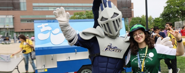 Lancer mascot Winston posing with orientation celebrant
