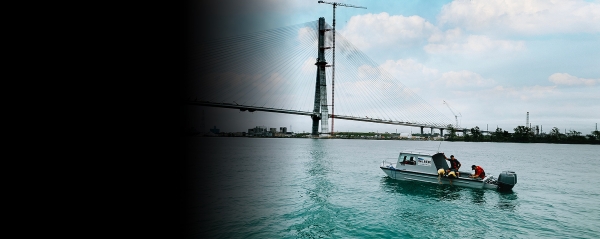 Researchers with the Great Lakes Institute for Environmental Research collect a water sample from a boat in the Detroit River