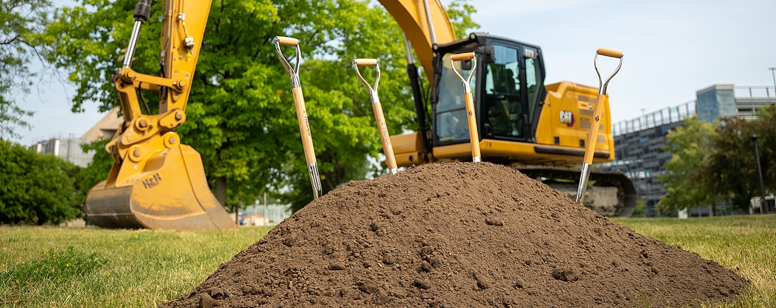 shovels stuck in pile of dirt opposite Alumni Hall