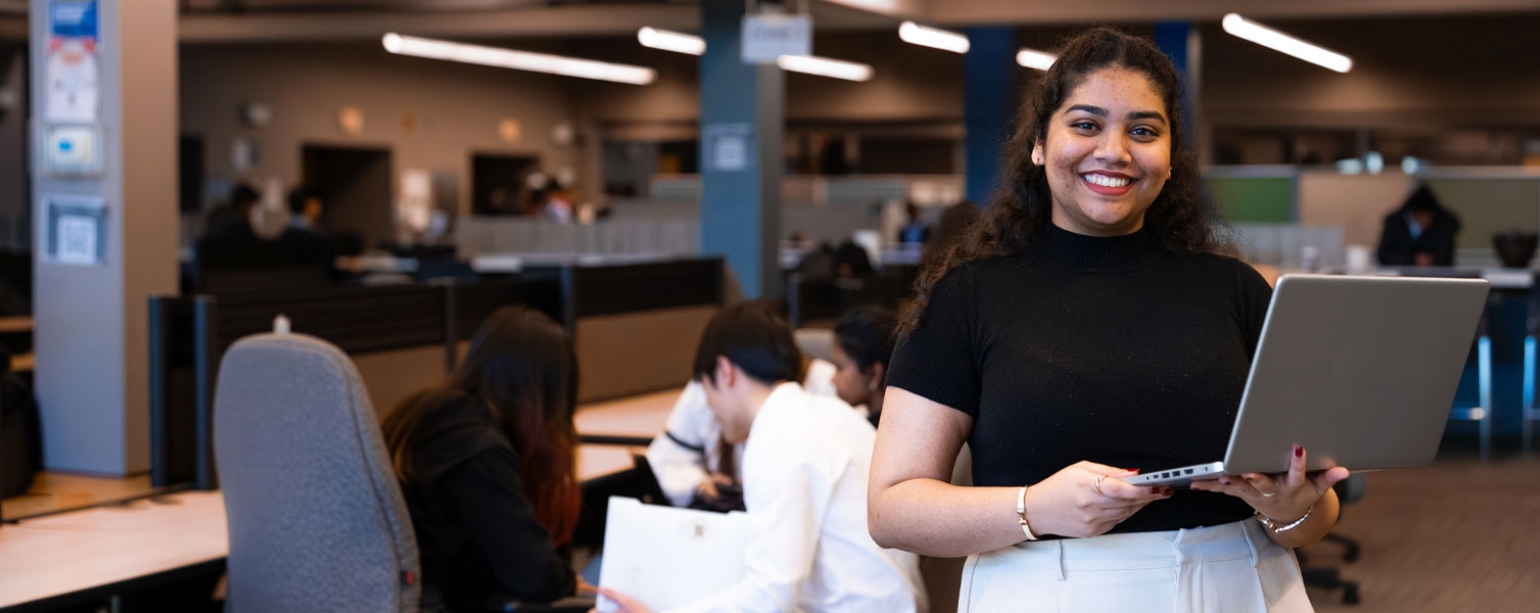 Girl standing holding laptop