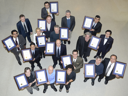 people in suits, holding certificates