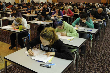 students bent over exam papers