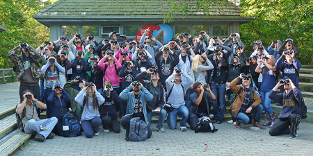 students looking up through binoculars