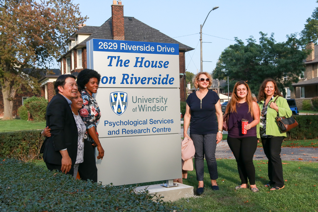 Guests pose in front of the sign at the new Psychological Services and Research Centre on Sept. 21, 2017.