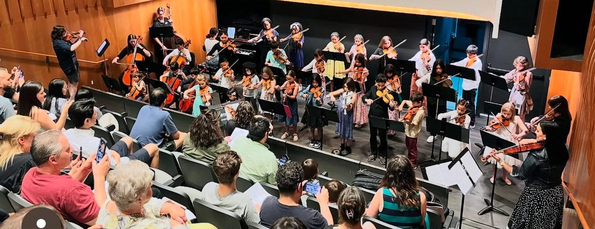 Students with instructors performing in front of a live audience