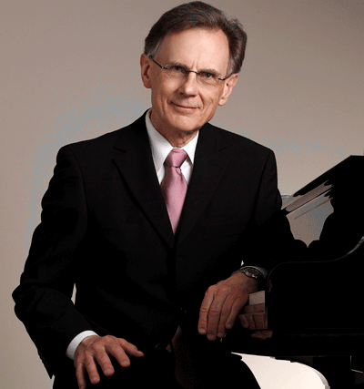 Classical pianist and pedagogue Dr. Philip Adamson sitting at a grand piano