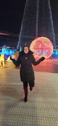 This is a photo of Brooke Castellan. Behind her appears to be a winter light festival