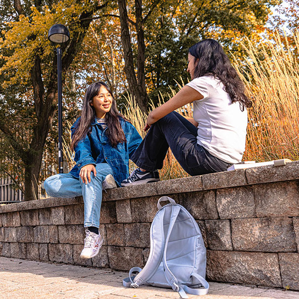 Two female students sitting outside