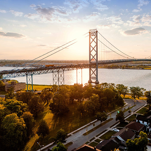 Drone view of Ambassador Bridge sun nearly setting in the distance