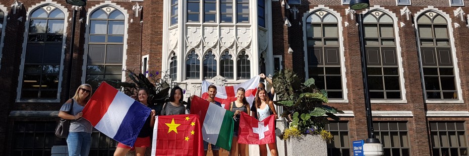 Incoming exchange students pose with flags at Dillon hall