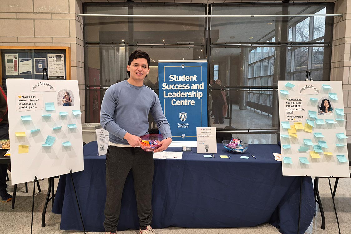 Student at a popup table promoting Student Success and Leadership Centre