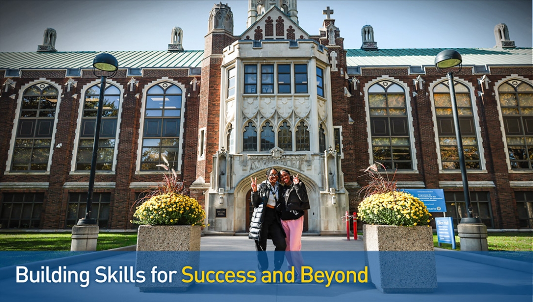 2 black female students standing and smiling in front of Dillon Hall
