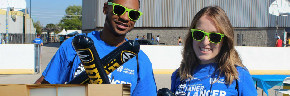 Two students posing with UWindsor swag