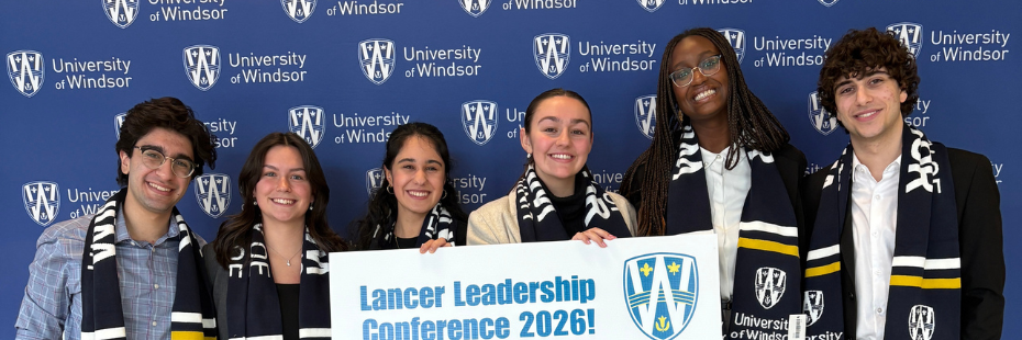 Student leaders standing in front of a UWindsor Banner