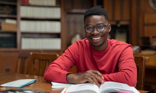 Image of Black student studying in a library setting