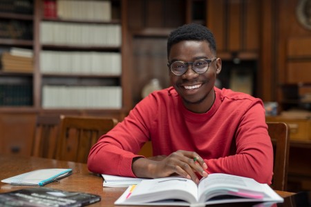 Image of Black student studying in a library setting