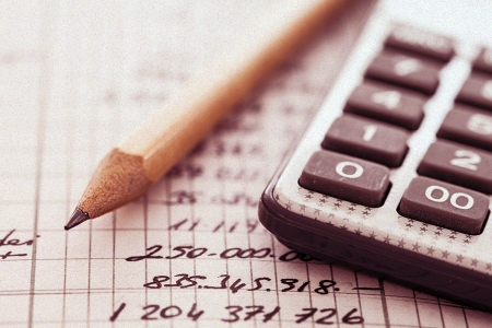 Closeup of calculator, pencil and budget paperwork