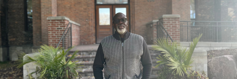 Dr. Beckford standing in front of Assumption Hall