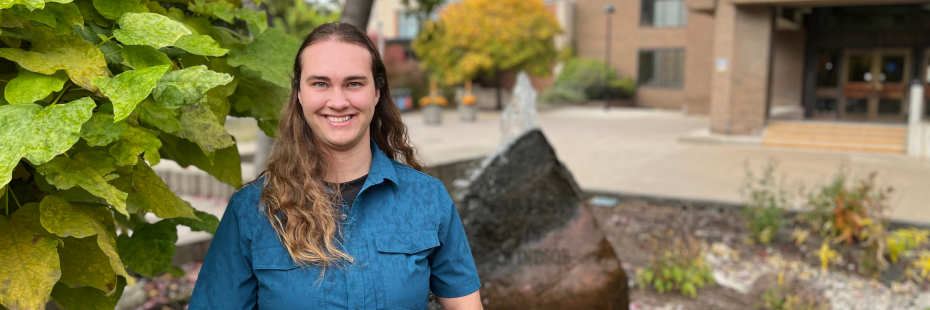 Meagan standing in front of a bubbling fountain by Leddy Library